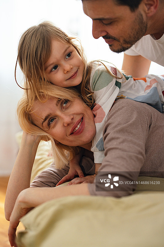 穿着睡衣的幸福家庭在卧室里一起玩耍图片素材