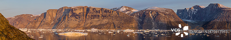日落时分的太阳照亮了格陵兰Uummannaq峡湾的冰川冰山图片素材