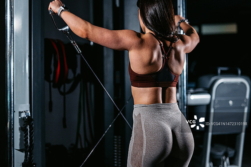 年轻女子在健身房做背部锻炼图片素材