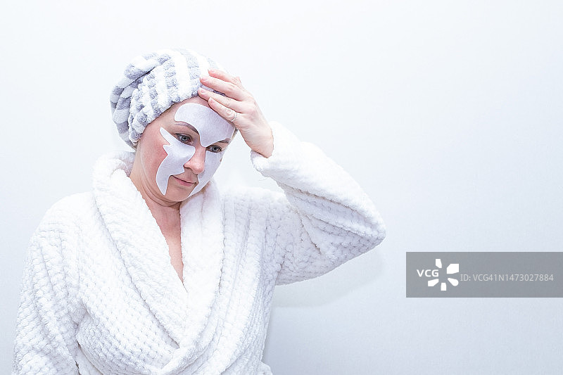 整容手术，一名白人妇女在她的脸上做美容面膜。图片素材