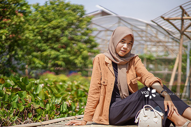 亚洲穆斯林妇女坐在竹桥上图片素材