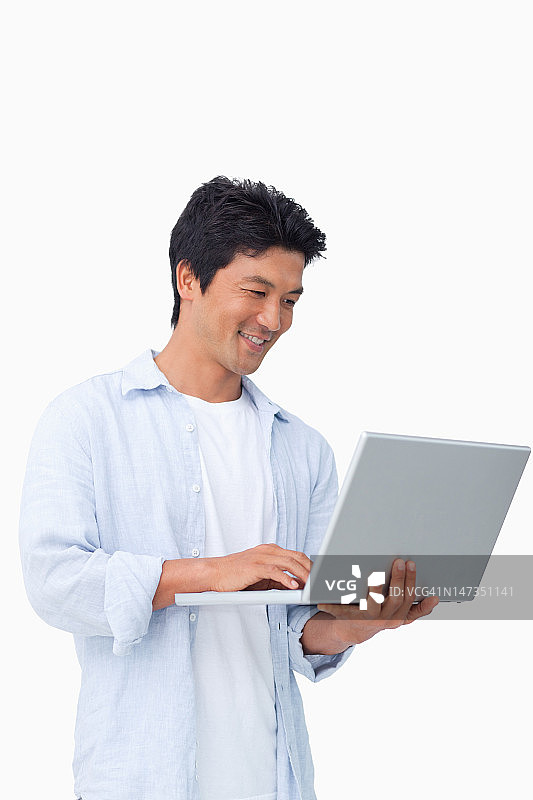 微笑的男性在他的笔记本电脑图片素材