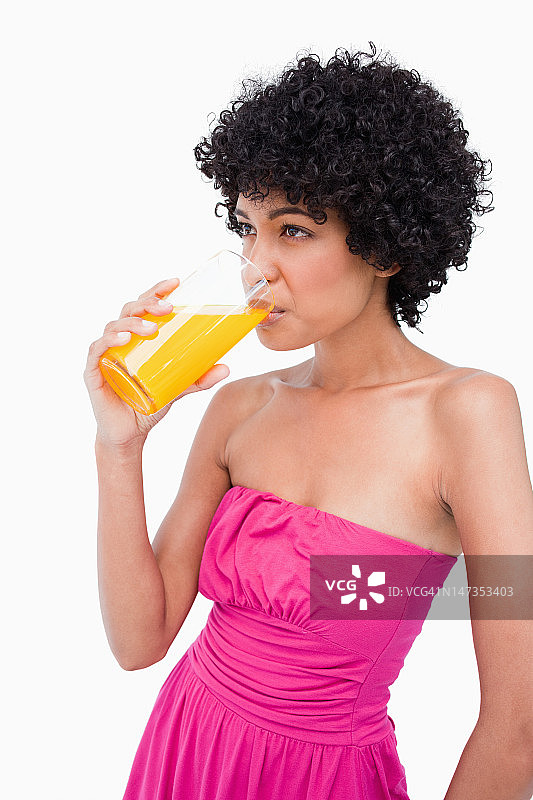 放松的少年喝着一杯橙汁图片素材