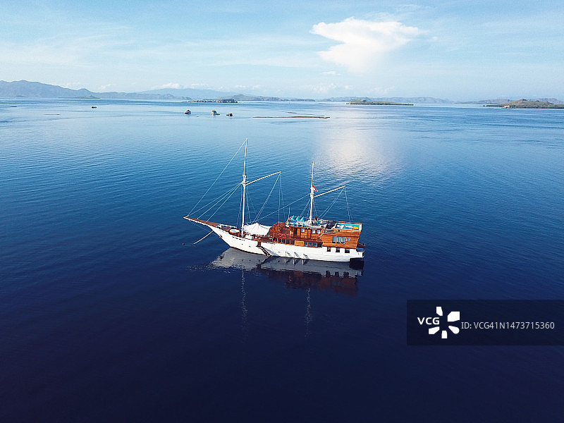 高角度视图的船航行在海上对天空，纳闽巴霍，印度尼西亚图片素材