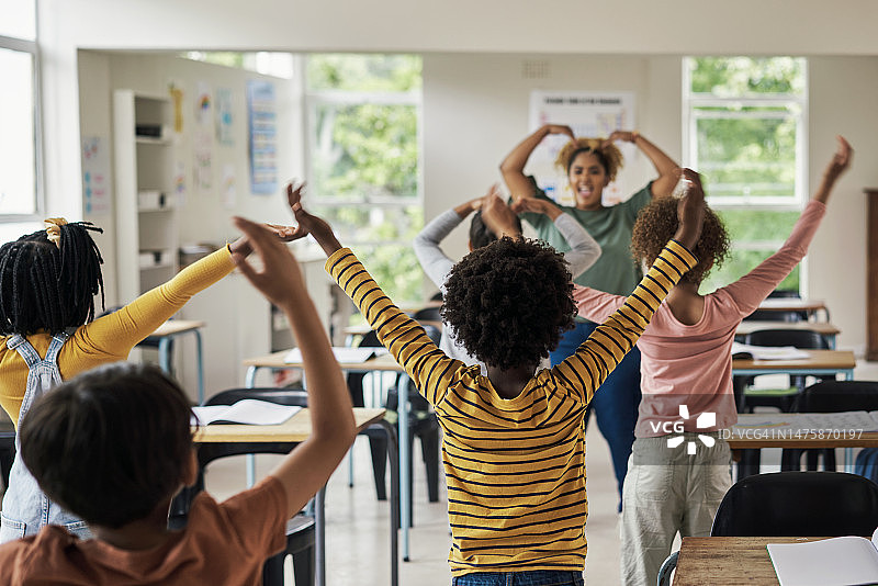 学校里，教室里的孩子们和老师一起学习舞蹈，兴奋、快乐、有趣。多元化，教育与孩子们与女性一起教学、跳舞、享受教育创意课程图片素材