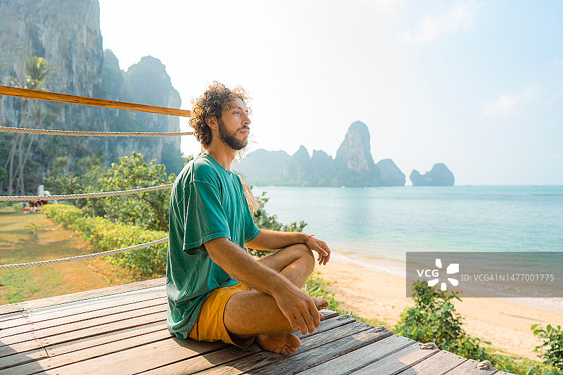 一名男子在甲米的海滩上冥想和做瑜伽图片素材