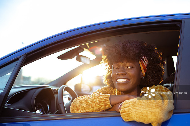 一个快乐的非裔美国女司机的肖像在车里图片素材