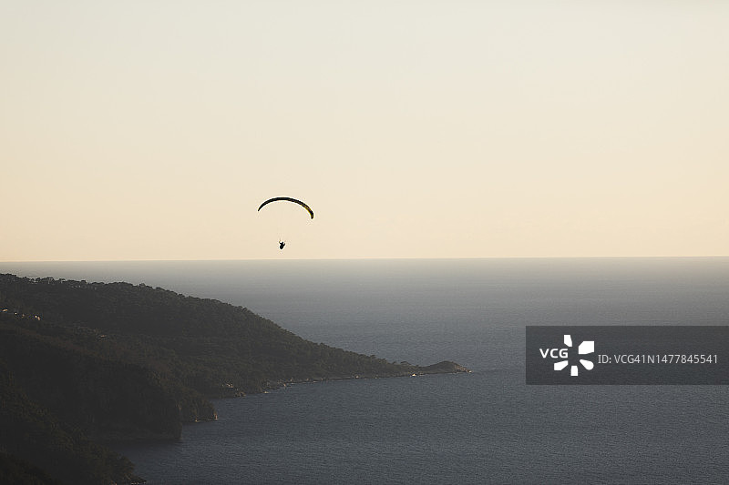 在日落期间，滑翔伞在天空的剪影图片素材