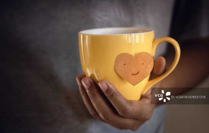 茶爱好者概念手握一杯茶环保风格标签制成心形，曼谷，泰国图片素材
