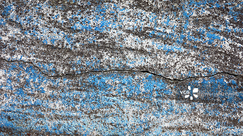 在法国上萨瓦省Evian-Les-Bains，被粉刷成白色和蓝色的开裂和风化的混凝土墙图片素材