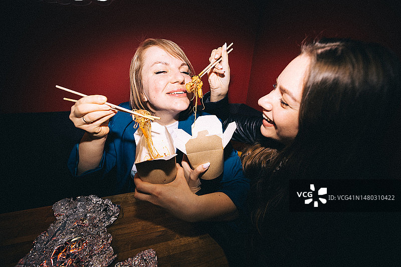 快乐的朋友吃面条从零浪费食品纸盒和木筷子图片素材