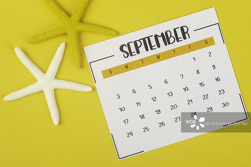 2023日历台:9月是组织者计划和截止日期的月份，黄色纸背景上有一只海星。图片素材