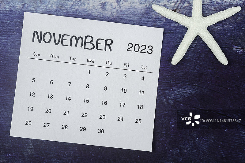 2023年日历台:11月是组织者用蓝色背景上的海星来计划和截止日期的月份。图片素材