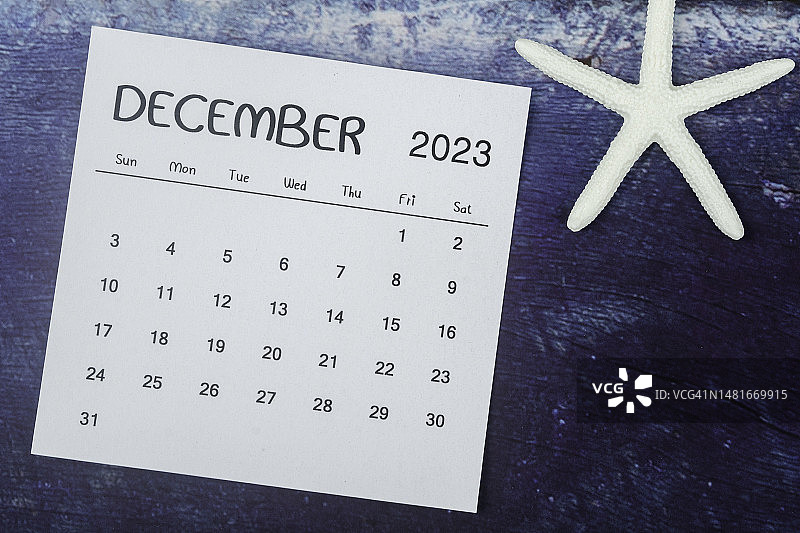 2023日历台:12月是组织者用蓝色背景上的海星来计划和截止日期的月份。图片素材