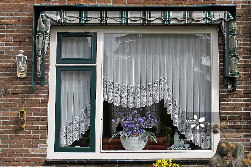 阿姆斯特丹的窗户上挂着鲜花和窗帘图片素材
