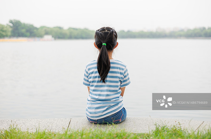 小女孩坐在湖边图片素材