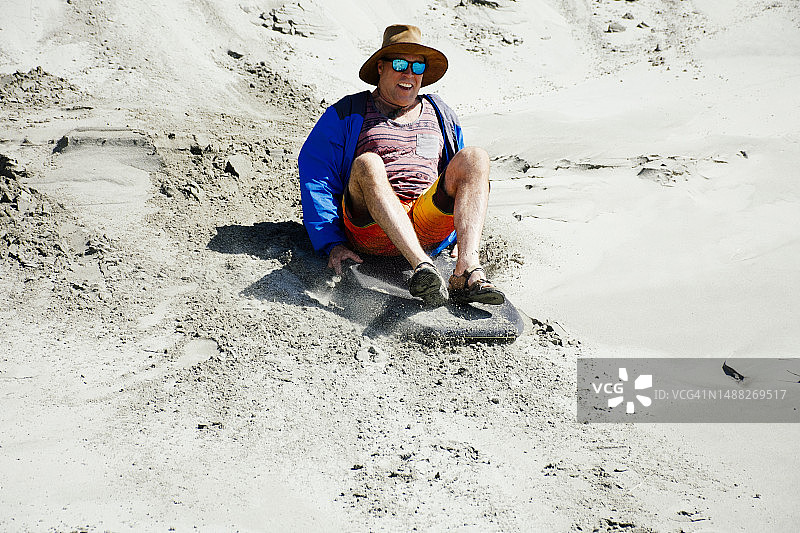 男子夏天在沙丘上玩沙板图片素材