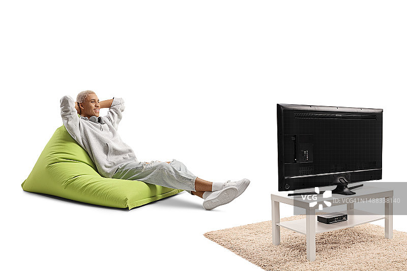 一个非洲裔美国人坐在沙发上看电视图片素材