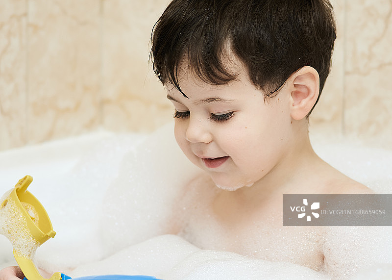 漂亮的小男孩在浴缸里玩耍图片素材