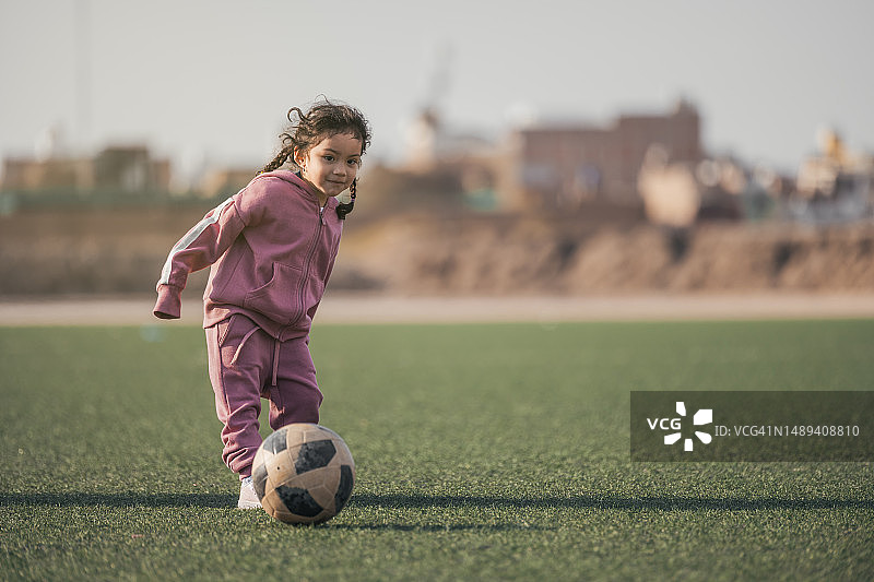 体育运动的孩子。快乐的小女孩孩子踢足球，孩子玩图片素材