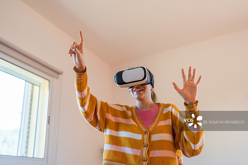 戴着VR眼镜玩虚拟现实视频游戏的女人玩得很开心。图片素材