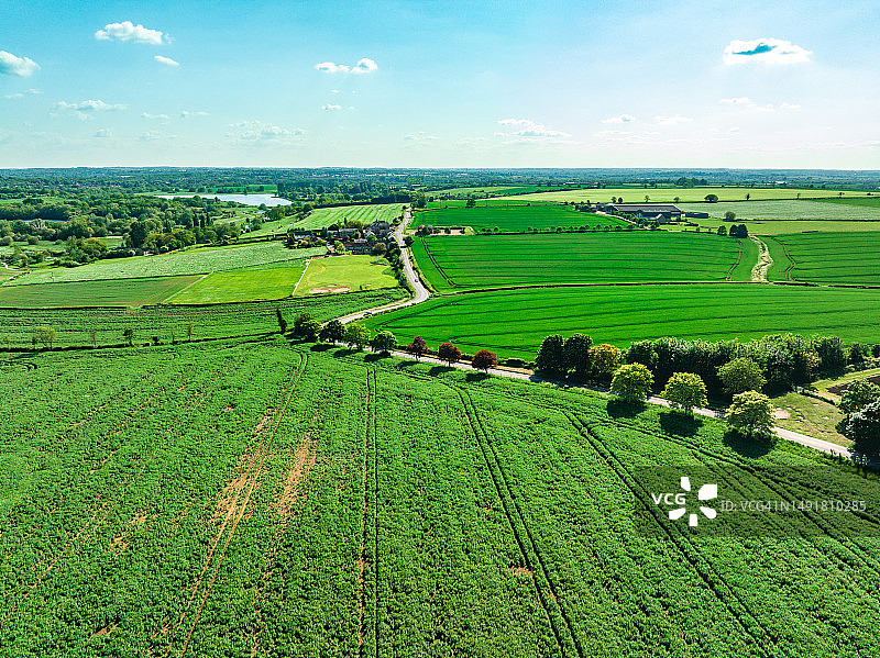 鸟瞰图，美丽的农田与多云的蓝天在英国图片素材