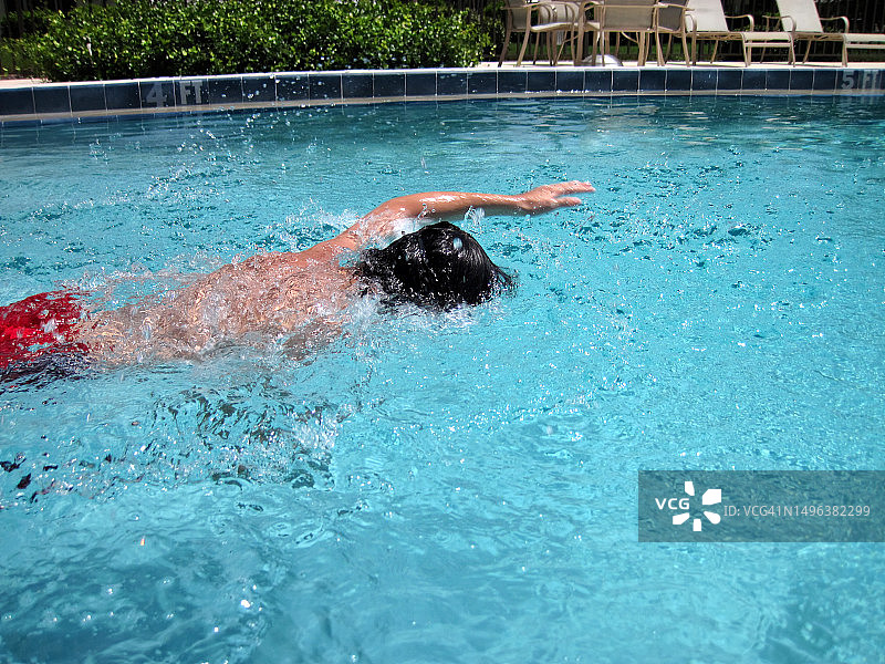 十几岁的男孩在游泳池游泳图片素材