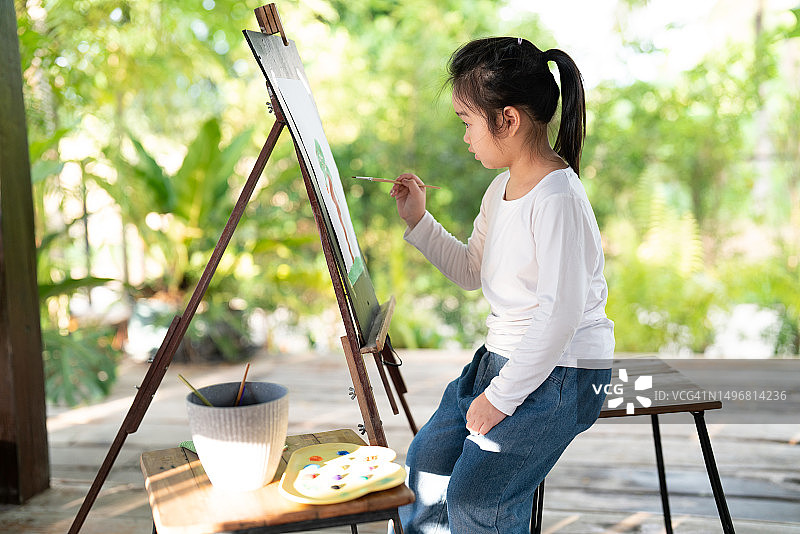 亚洲小女孩在后院享受绘画艺术的休闲活动图片素材