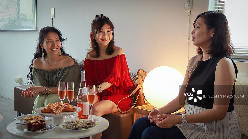 一群女人一边聊天一边享用下午茶点心和白葡萄酒图片素材