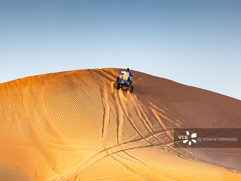 一个人骑着摩托车在沙漠上迎着天空图片素材