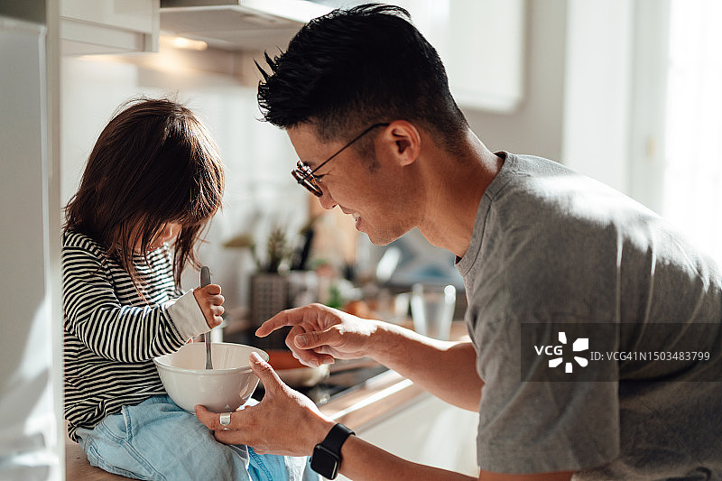 年轻的亚洲父亲和女儿在家里的厨房一起做饭图片素材