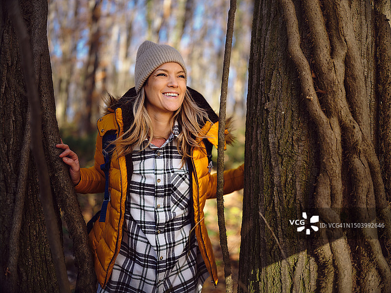 快乐的女性背包客在大自然的树林中休息。图片素材