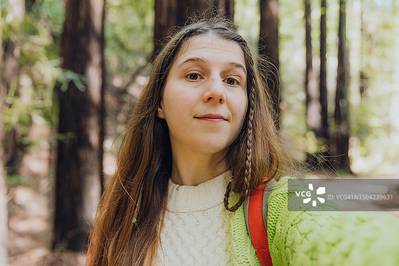 一名女子在加州菲佛大苏尔州立公园风景秀丽的红杉林中自拍图片素材