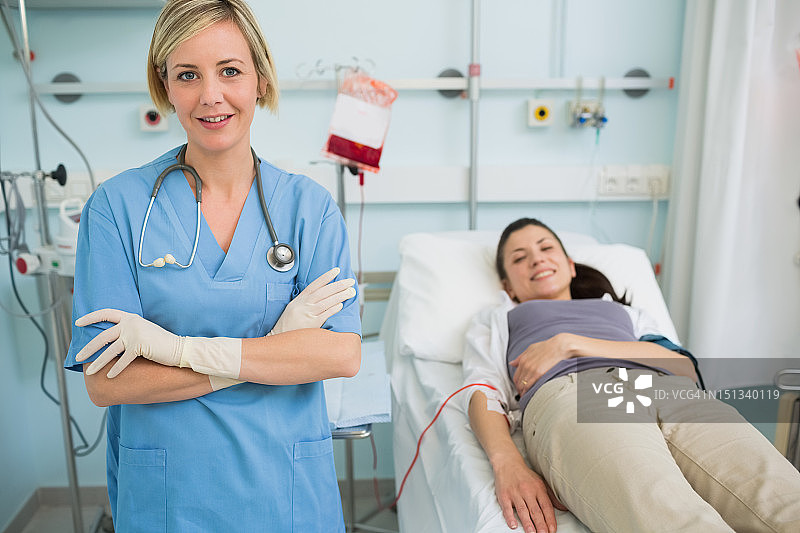 护士站在一位女性输液病人旁边图片素材