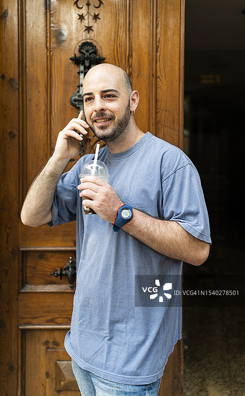 男人一边喝着外卖咖啡一边打电话图片素材