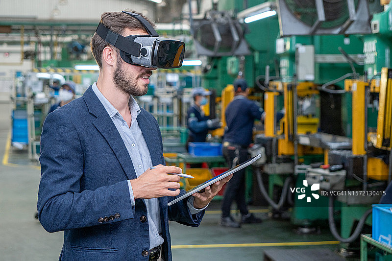 工程师在平板电脑上戴着虚拟现实眼镜进行未来研究。图片素材