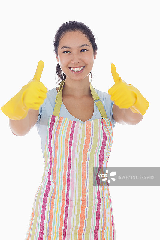 戴着橡胶手套竖起大拇指的快乐女人图片素材