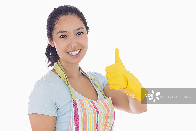 戴着黄色橡胶手套竖起大拇指的女人图片素材