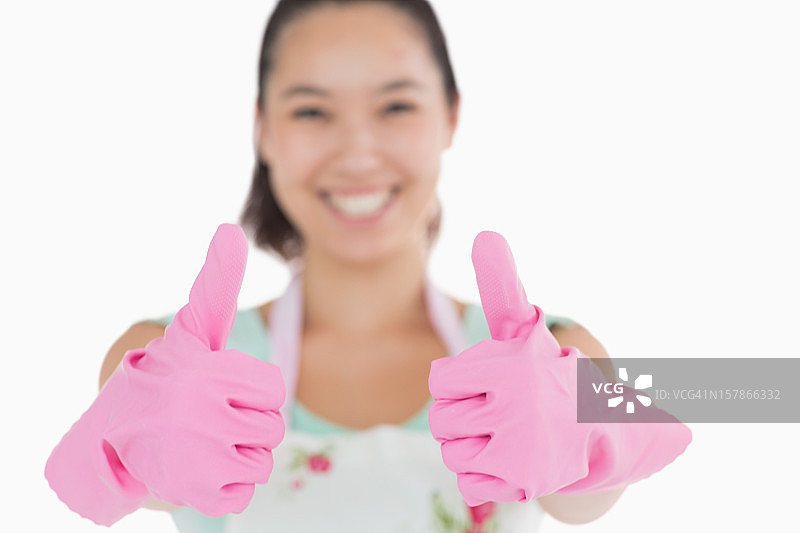 戴着手套微笑的女人竖起大拇指图片素材