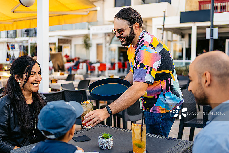 服务员在海边咖啡馆上鸡尾酒图片素材