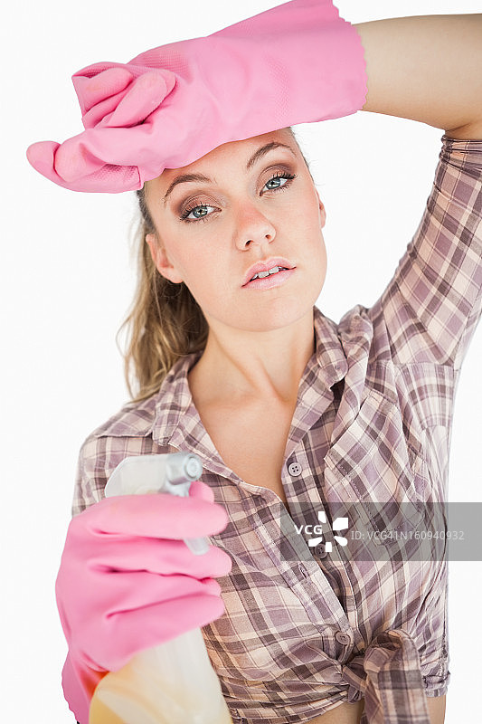 一个疲惫的年轻女子拿着喷雾器的肖像图片素材