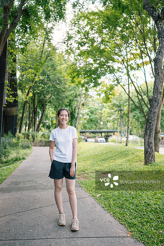 积极运动的女性早上在她家周围的花园里跑步图片素材