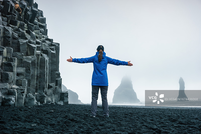 冰岛女子敬畏Reynisfjara黑沙滩景观图片素材