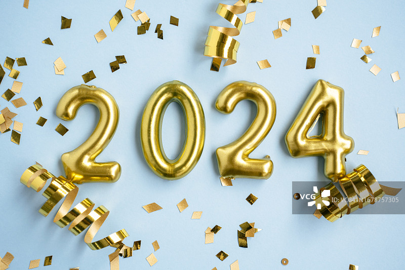 2024年新年号。蓝色背景上的金色数字和五彩纸屑。图片素材