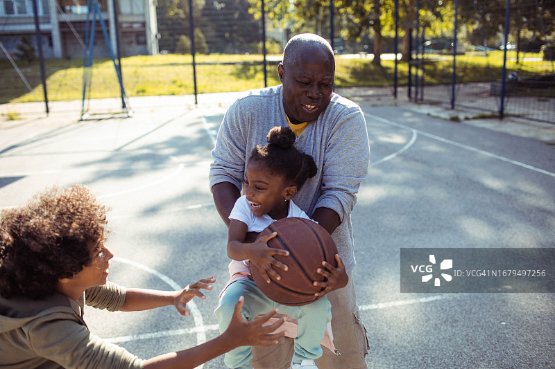 爷爷和孙子们在户外篮球场打篮球图片素材