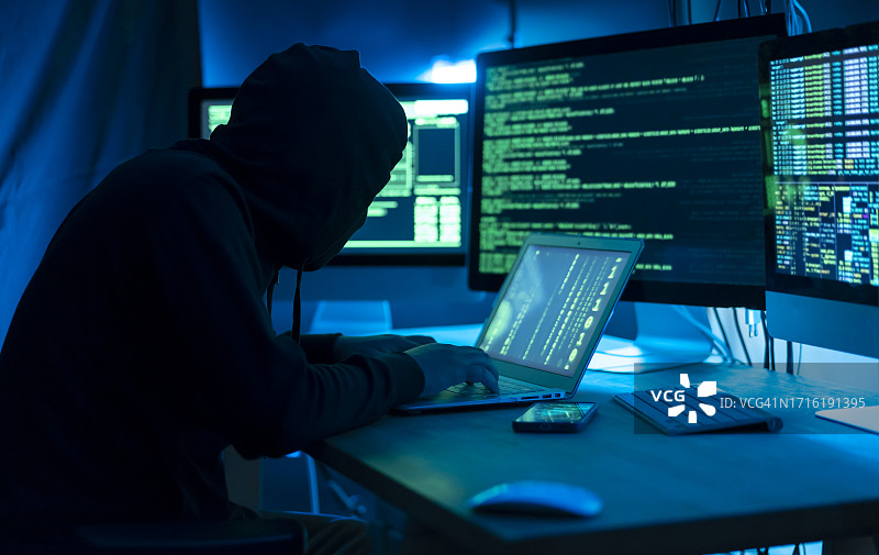 黑客在暗室里用电脑。网络犯罪图片素材
