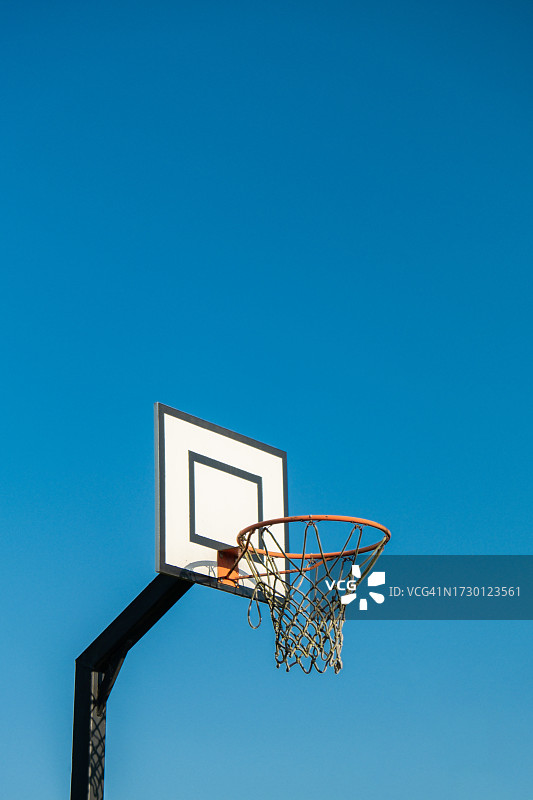 低角度的篮球篮对着晴朗的蓝天图片素材