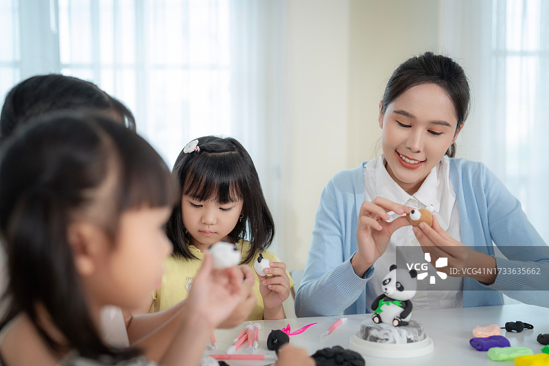 亚裔老师和她的小学生在彩陶模塑课上图片素材