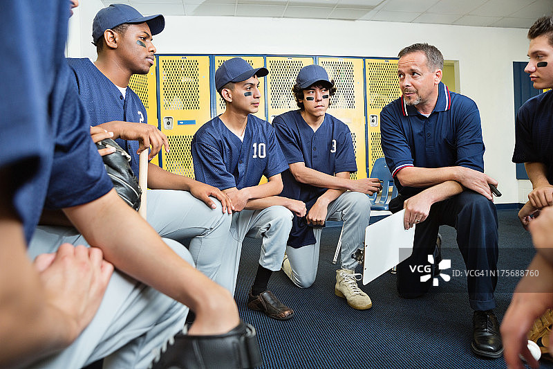 高中棒球教练在更衣室里和球员交谈图片素材