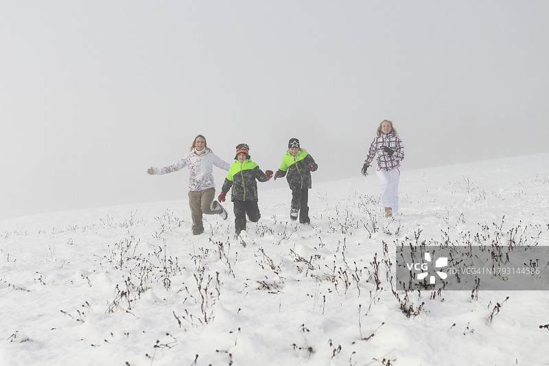 雪中奔跑的家庭图片素材